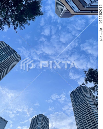 高層ビルに囲まれた青空と白い雲を見上げる都市風景 高層ビルに囲まれた青空と白い雲を見上げる都市風景 143562016