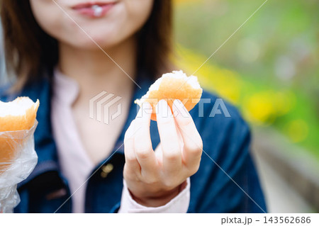 屋外で福田パンを食べる女性 屋外で福田パンを食べる女性 143562686