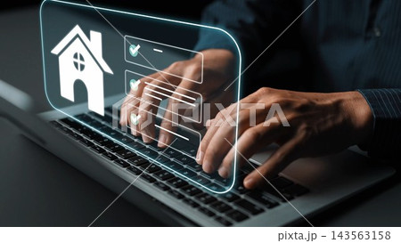 Hands typing on a laptop with a glowing home icon and check marks, representing online real estate searches and digital property transactions Gluon 143563158