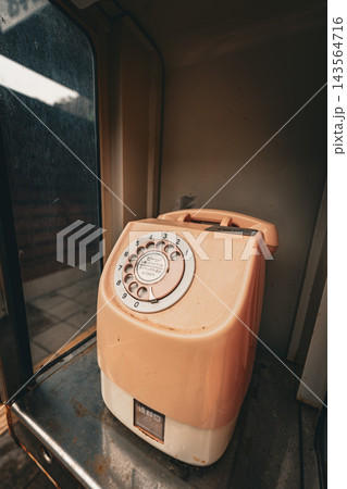 昭和レトロなダイヤル式ピンクの公衆電話のクローズアップ 143564716