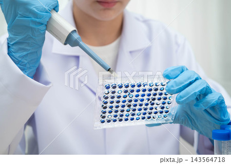 Scientist with cell culture in sample micro plate for research in science laboratory. Scientist with cell culture in sample micro plate for research in science laboratory. 143564718