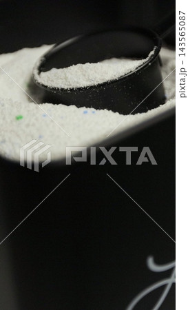 Vertical video. Container with washing powder. Clothes cleaning, laundry service. Household chore concept. 143565087