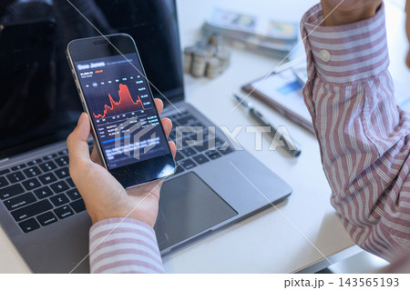 Stressed Investor Looking at Market Crash Stock Chart on Phone in Office. 143565193