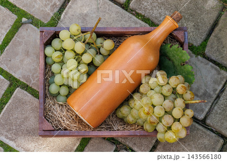 Ceramic Bottle and Grapes in a Wooden Crate, Top View Ceramic Bottle and Grapes in a Wooden Crate, Top View 143566180