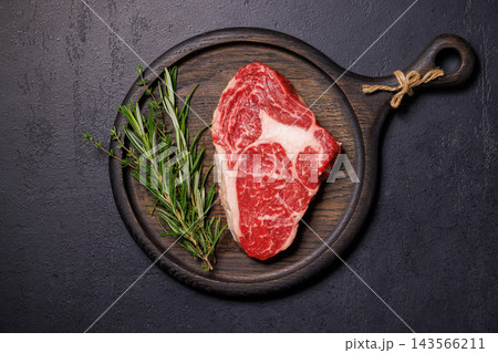 Butcher cut beef with salt pepper and fresh thyme - beside a carving knife 143566211