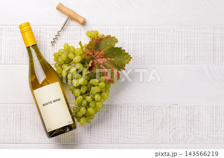 White wine still life with ripe grapes and vine leaves White wine still life with ripe grapes and vine leaves 143566219