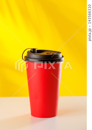 Red takeaway coffee cup on yellow background Red takeaway coffee cup on yellow background 143566310