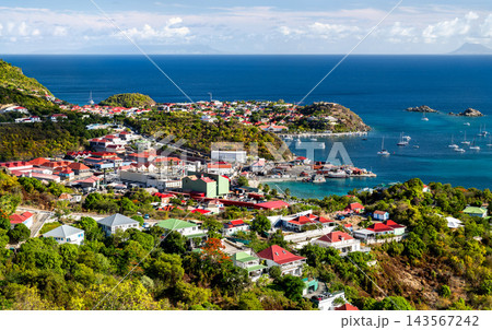 Aerial view of coastal houses, harbor facilities and boats on the turquoise sea in Gustavia, Saint Barthelemy, a French Caribbean Island Aerial view of coastal houses, harbor facilities and boats on the turquoise sea in Gustavia, Saint Barthelemy, a French Caribbean Island 143567242