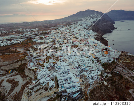 Aerial Drone View of Oia, Santorini. A breathtaking aerial view of the whitewashed village of Oia, Santorini, showcasing luxury resorts with infinity pools overlooking the Aegean Sea. A stunning blend Aerial Drone View of Oia, Santorini. A breathtaking aerial view of the whitewashed village of Oia, Santorini, showcasing luxury resorts with infinity pools overlooking the Aegean Sea. A stunning blend 143568339