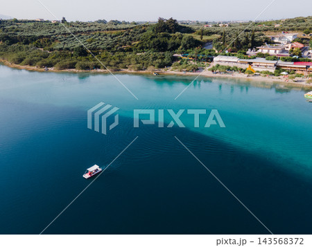 Aerial Panorama of Lake Kournas, Crete. Stunning aerial drone view of the natural Lake Kournas in Chania, Crete. The turquoise waters reflect the surrounding hills, while white pedal boats float peace Aerial Panorama of Lake Kournas, Crete. Stunning aerial drone view of the natural Lake Kournas in Chania, Crete. The turquoise waters reflect the surrounding hills, while white pedal boats float peace 143568372