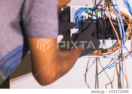 Electrician placing and adjusting circuit breakers. Electrician placing and adjusting circuit breakers. 143572504