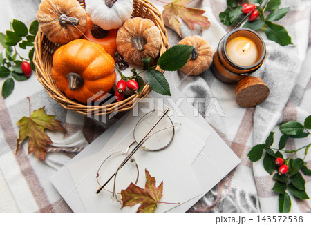 Autumn flat lay with pumpkins, candle, and warm blanket 143572538