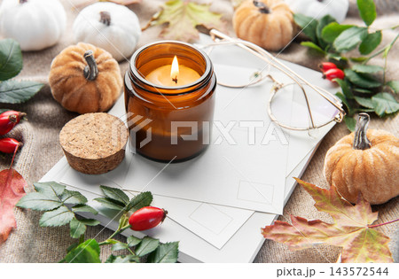 Lit candle creating cozy autumn hygge mood Lit candle creating cozy autumn hygge mood 143572544