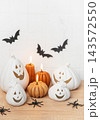 Decorating for halloween with ceramic pumpkins and lit candles 143572550