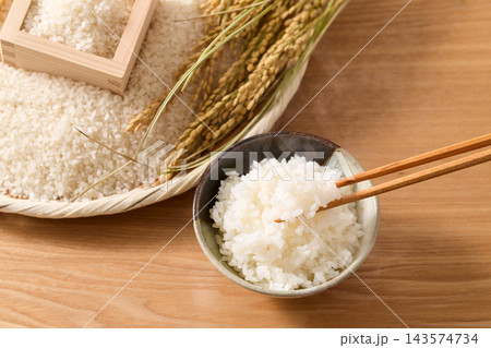 茶碗によそったご飯とざるに盛ったお米 143574734