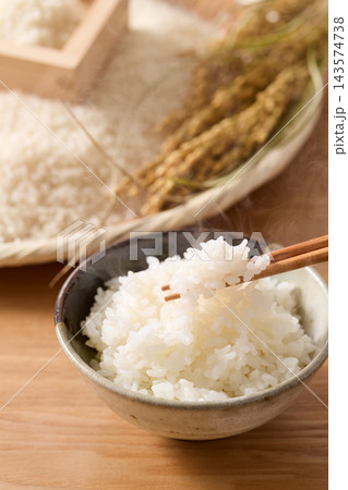 茶碗によそったご飯とざるに盛ったお米 茶碗によそったご飯とざるに盛ったお米 143574738