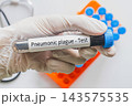 Gloved hand holding Pneumonic Plague labeled blood tube, infectious disease medical testing concept 143575535