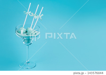 Turquoise cake pops with ribbon bows in cocktail glass with colored sugar on blue background with copy space Turquoise cake pops with ribbon bows in cocktail glass with colored sugar on blue background with copy space 143576844