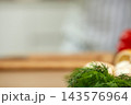 Fresh dill herb resting on a wooden countertop in a kitchen setting, ready for food preparation and cooking 143576964