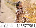 ススキの中で目を閉じる女性 143577564