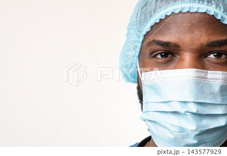 Close up of young african american man surgeon face over white background, empty space Close up of young african american man surgeon face over white background, empty space 143577929