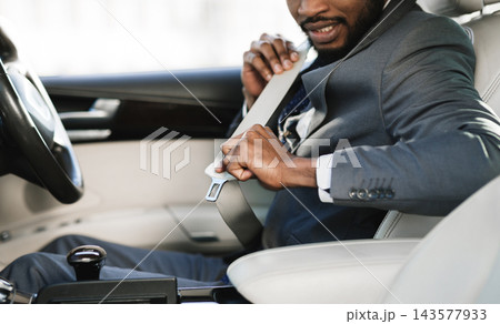 Car safety. Business man fastening seat belt in auto, driving to work, copy space Car safety. Business man fastening seat belt in auto, driving to work, copy space 143577933