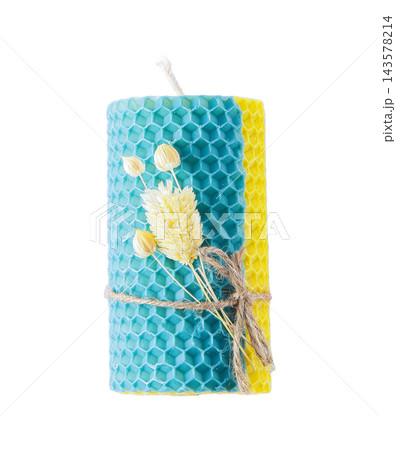 Candle isolated on white background. Handmade yellow and blue beeswax candle 143578214