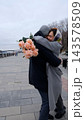A loving couple hugs and twirls during a walk through the city during the cold season. 143578509