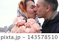 Husband and wife cheek to cheek with pink roses. Tenderness, trust and a happy marriage. 143578510