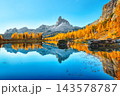 Amazing autumn view of  Lake Federa  at sunrise with majestic rocky mount and colorful trees glowing sunlight in Dolomites 143578787