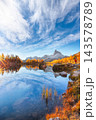 Amazing autumn view of  Lake Federa  at sunrise with majestic rocky mount and colorful trees glowing sunlight in Dolomites 143578789