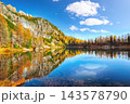 Amazing autumn view of  Lake Federa  at sunrise with majestic rocky mount and colorful trees glowing sunlight in Dolomites 143578790