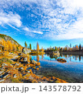 Amazing autumn view of  Lake Federa  at sunrise with majestic rocky mount and colorful trees glowing sunlight in Dolomites 143578792