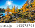 Amazing autumn view of  Lake Federa  at sunrise with majestic rocky mount and colorful trees glowing sunlight in Dolomites 143578793