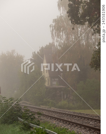 Old country house next to railway tracks in thick fog Old country house next to railway tracks in thick fog 143581906