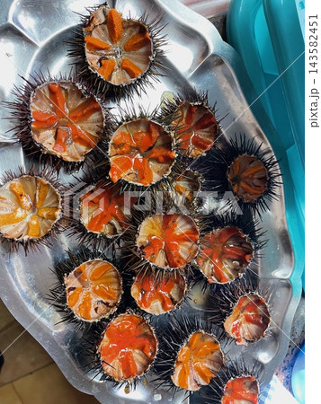 Fresh sea urchins cut open and ready to eat as a seafood delicacy Fresh sea urchins cut open and ready to eat as a seafood delicacy 143582451