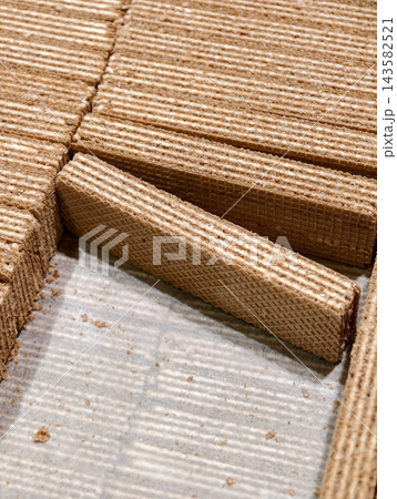 Milk wafers stacked in neat rows inside a box displayed in a supermarket, showcasing sweet baked products arranged attractively for customers choosing from the selection Milk wafers stacked in neat rows inside a box displayed in a supermarket, showcasing sweet baked products arranged attractively for customers choosing from the selection 143582521
