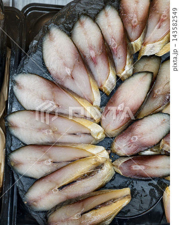 Dry aged mackerel sliced into layers and beautifully arranged on a seafood display at a traditional fish market Dry aged mackerel sliced into layers and beautifully arranged on a seafood display at a traditional fish market 143582549