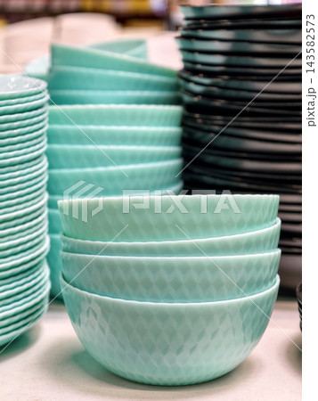 Light blue salad bowls with ribbed surface texture and rounded shape stacked neatly for kitchen tableware Light blue salad bowls with ribbed surface texture and rounded shape stacked neatly for kitchen tableware 143582573