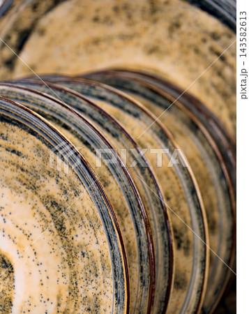 Beautiful yellow ceramic plates on shelves in supermarket, close up of luxurious tableware for kitchen and household use Beautiful yellow ceramic plates on shelves in supermarket, close up of luxurious tableware for kitchen and household use 143582613