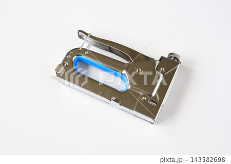 Metal construction stapler tool isolated on white background. Professional hand tacker hardware for carpentry work and home renovation, furniture repair and upholstery, stretching canvas Metal construction stapler tool isolated on white background. Professional hand tacker hardware for carpentry work and home renovation, furniture repair and upholstery, stretching canvas 143582698