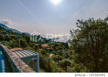 French Riviera town and coastline beneath wooded hills. French Riviera town and coastline beneath wooded hills. 143582991