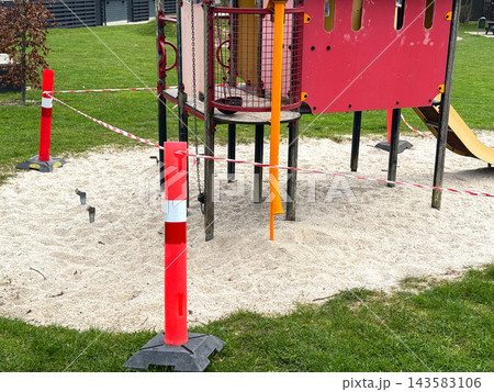 Closed playground with barrier tape and warning cones 143583106