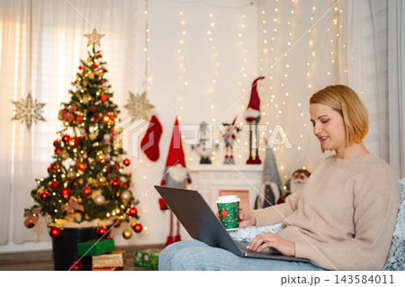 Woman using laptop at home celebrating Christmas holiday 143584011