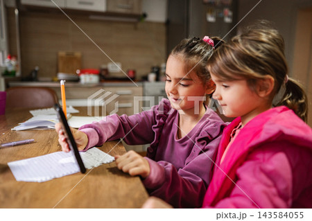 Schoolgirls learning with smartphone and pencil at home Schoolgirls learning with smartphone and pencil at home 143584055