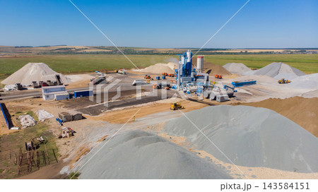 Industrial site with machinery and sand piles in open landscape during daytime 143584151