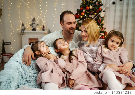 Family celebrating Christmas together at home with three daughters 143584238