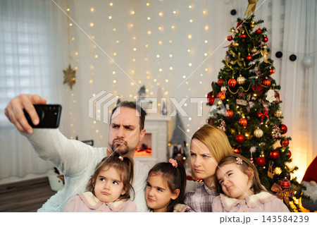 Family making funny faces while taking Christmas selfie 143584239