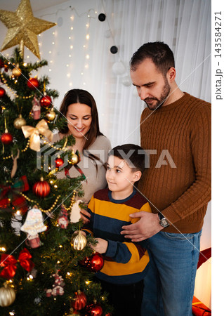 Family decorating Christmas tree together at home 143584271
