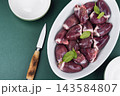 Raw turkey offal in baking dish with herbs and spices 143584807